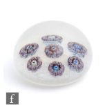 A large Parabelle glass paperweight with spaced millefiori garlands with central silhouette canes to