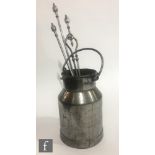 A steel swing handled milk churn and a set of three matching fire irons. (4)