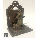 A 20th Century Austrian painted spelter bookend of an Arabian carpet seller and a seated semi-