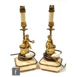 A pair of 20th Century gilt candlesticks each mounted with a cherub playing a musical instrument, on