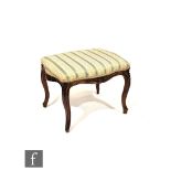 A Victorian carved walnut dressing table stool on cabriole legs, in blue stripped damask, width