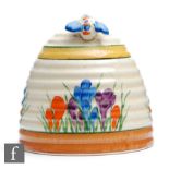 A Clarice Cliff beehive honey pot hand painted with crocus sprays within yellow, green and brown