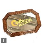 A bevelled glass advertising mirror with Cadbury's Cocoa in gold (beneath the plate) within an oak