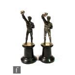 A pair of figures modelled as fencers in standing pose each with right arm aloft and mounted to a