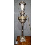 A Victorian plated Corinthian column table lamp with detach eagle reservoir on beaded square base,