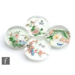 A group of four Chinese glass paperweights, of domed form each internally decorated with a floral