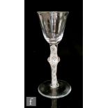 An 18th Century drinking glass circa 1760, the round funnel bowl above a multiple series opaque