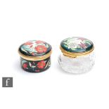 Two Moorcroft Enamel trinket boxes, the first decorated with red flowers, the second with purple and