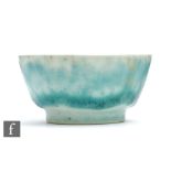 A small Ruskin Pottery footed bowl decorated in an all over tonal mottled green, impressed mark