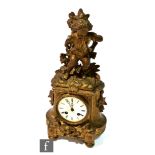 A late 19th Century French gilt mantle clock surmounted with a boy carrying a basket of corn,