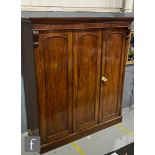 A large William IV triple panel mahogany wardrobe enclosed fitted end section enclosed by panelled