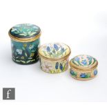 Three Moorcroft Enamel trinket boxes each with hand painted floral decoration, all boxed, largest
