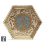 A Royal Copenhagen hexagonal dish decorated with a kneeling fisherman hooking a fish, in gold