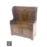 A small 17th Century style carved oak high back settle with box seat over a panel front, height