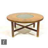 A 1970s G-Plan teak coffee table of circular form with smoked glass inset top, on brass capped