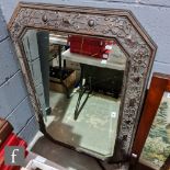 A 1920s carved oak octagonal wall mirror, 114cm x 78cm.