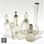 Seven silver topped or collared oil or perfume bottles including a plain example and desk weight