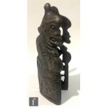 A 20th Century tiki hardwood grotesque figure carved in profile, the hinged covers revealing a