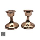 A pair of hallmarked silver piano candlesticks of plain swept form, heights 9cm, Chester 1926.