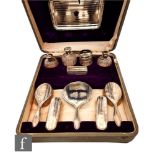 A cased hallmarked silver thirteen piece dressing table set comprising four brushes, hand mirror,