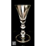 An 18th Century drinking glass circa 1750, the bell bowl above a drop knop and inverted baluster