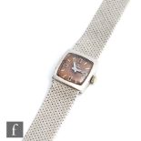 A lady's 9ct white gold Marvin manual wrist watch, batons to a square tan dial and integral 9ct