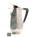 A hallmarked silver milk jug of plain panelled form with flip cover and angular wooden handle,
