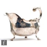 A George III hallmarked silver sauce boat of plain form, raised on three stepped pad feet and