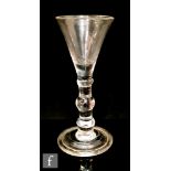 A mid 18th Century balustroid gin glass circa 1740, the trumpet bowl above a triple knopped stem