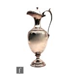 A hallmarked silver claret jug of plain baluster form detailed with an engraved chevron band below