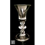 An 18th Century wine glass circa 1710, the bell bowl above a cushion shoulder knop, medial angle