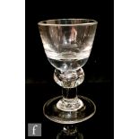 An 18th Century heavy baluster dram glass circa 1700, the round funnel bowl above a teared