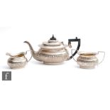 A hallmarked silver boat shaped three piece tea set with part fluted decoration, presentation