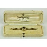 A 15ct gold and seed pearl Bar Brooch, with circular centre. (1)