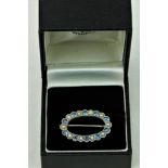 An attractive 18ct white gold oval Brooch Set, with 10 sapphires (.08 each) and pearls, with pin