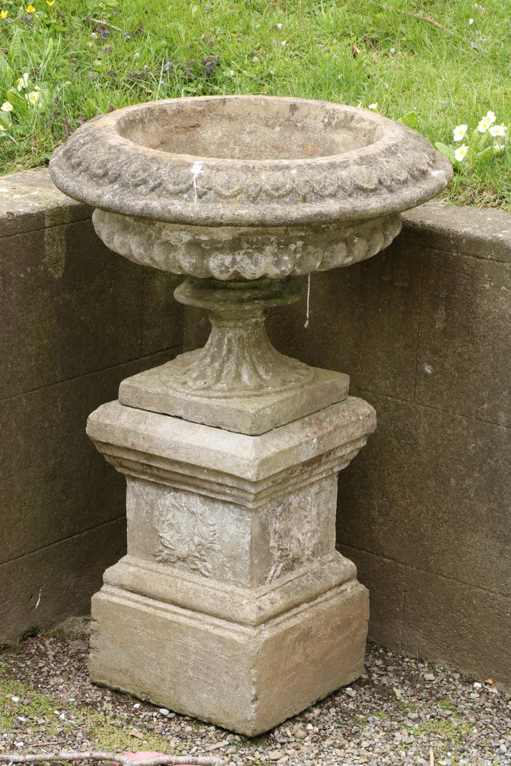A nicely weathered composition stone Urn and plinth, with half reeded body. (1)