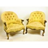 A fine almost matching pair of early 19th Century giltwood Saloon Armchairs, with carved arms and