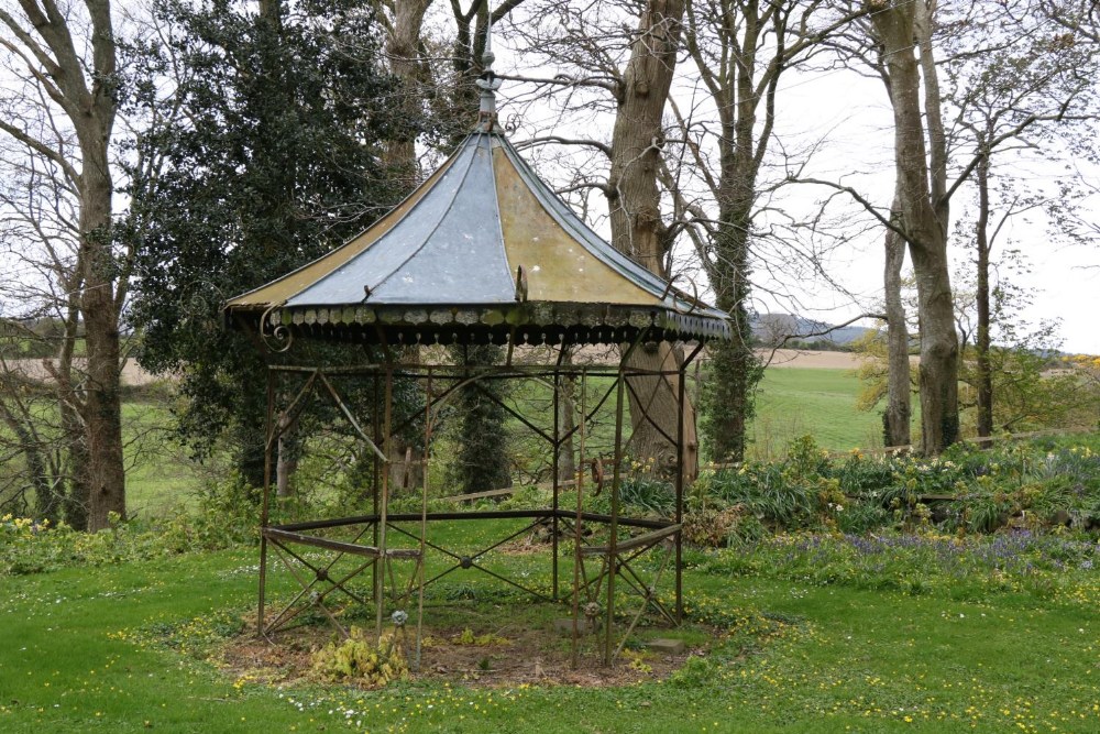 An attractive hexagonal shaped wrought iron Garden Gazebo, with galvanised domed roof, some