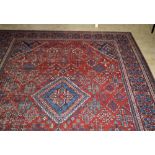 A good late 19th Century dark red ground Carpet, with large central lozenger and with large blue