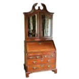 A fine quality Georgian period Irish mahogany Bureau Cabinet, the swan neck broken pediment with