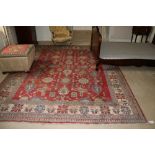 An attractive Oriental design Carpet, the red ground with multiple decoration, inside a large