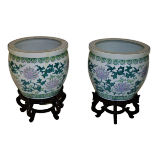 A pair of large modern Chinese Fish Bowls, decorated with stylized flowers on hardwood stands,