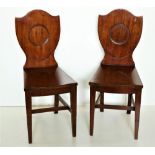 A pair of Irish 19th Century mahogany shield back Hall Chairs, the backs with circular indents