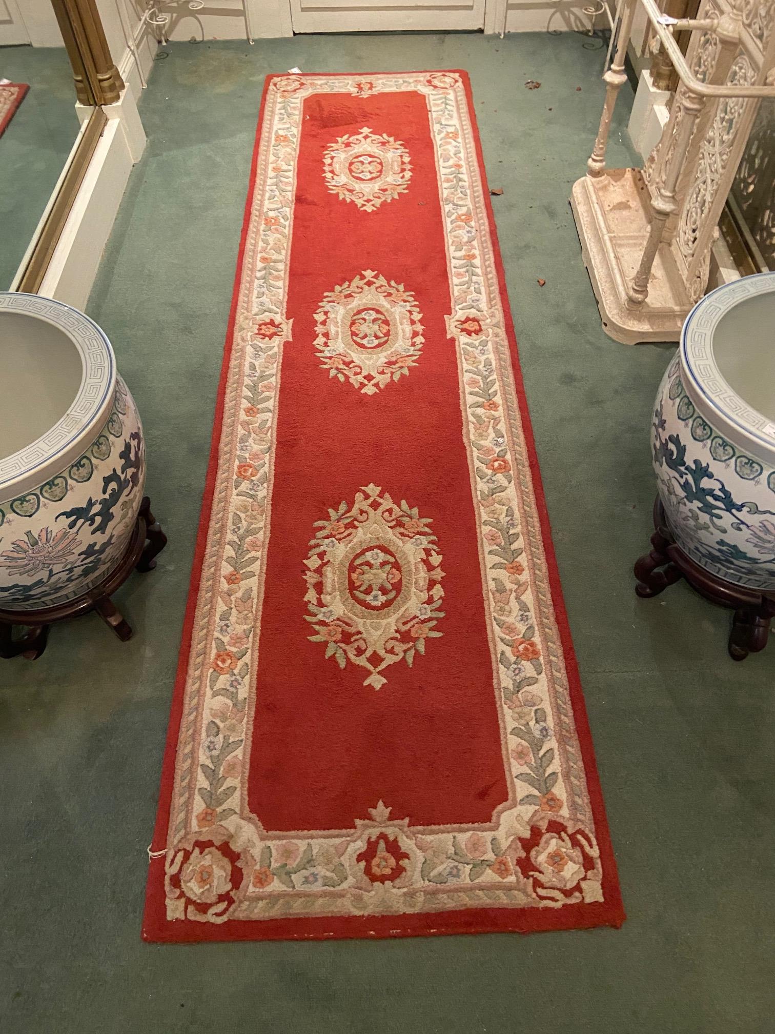 A set of three red/pink ground woollen Runners, each with a cream ground floral border and three - Image 8 of 8