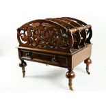 A Victorian walnut Canterbury, with pierced and arched dividing panels united by turned rails