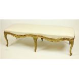 A large 19th Century gilt Window Stool, with padded seat of serpentine form raised on six leaf