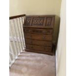 A 17th Century style oak slope front Bureau, with linen fold panels above four long drawers on