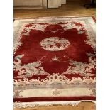 A fine Chinese burgundy ground heavy wool Carpet, with centre dragon medallion and dragon