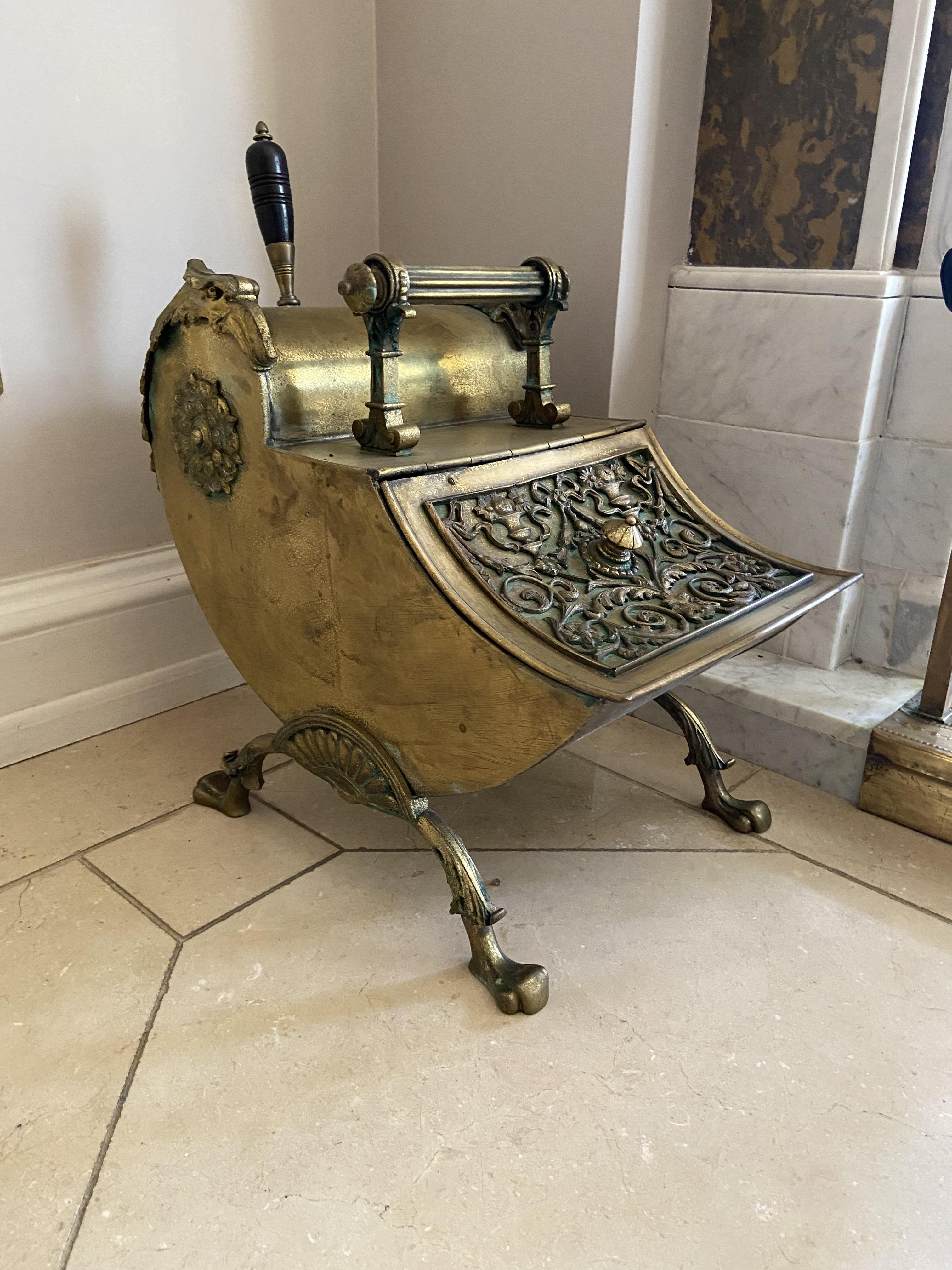 A very unusual brass Coal Scuttle, with scroll shaped body and ornate hinged front raised on four