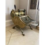 A very unusual brass Coal Scuttle, with scroll shaped body and ornate hinged front raised on four